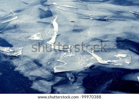 Beautiful frozen blue water covered by the snow and ice pieces. Winter landscape background.
