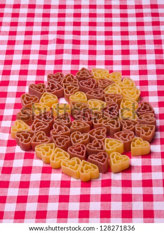 Bunch of heart shape pasta on a tablecloth.