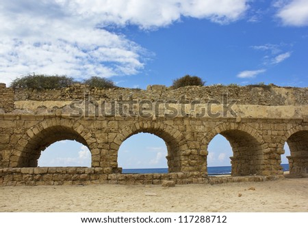 stone arches of ancient Roman aqueduct at Caesarea along the coast of the Mediterranean Sea, Israel.