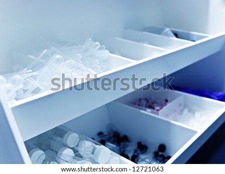 White lab bin full with research supplies in a chemistry or biology lab - cool blue tint