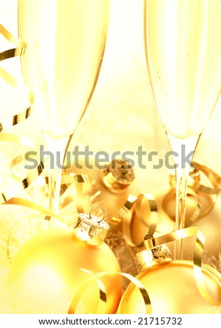 Glasses of champagne and Christmas ornaments with festive golden glow