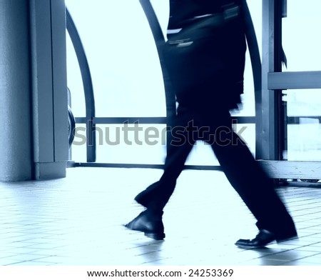 Man in business suit walking through airport terminal - long exposure for motion blur effect
