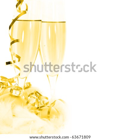 Glasses of champagne and Christmas ornaments with festive golden glow