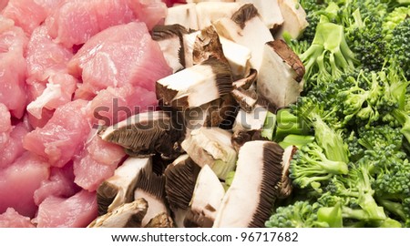 Assortment of raw mushrooms, broccoli, and white meat