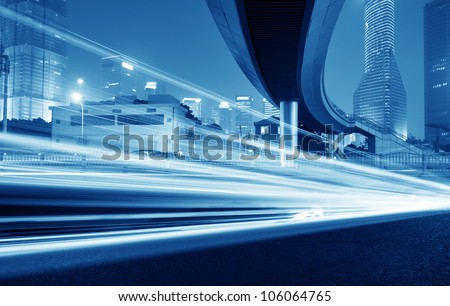 High-speed vehicles bright light trails on urban roads under the overpass at night