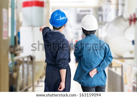 A team of construction workers with  helmets at work place in a factory