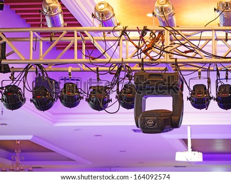 Studio lighting equipment high above an outdoor theatrical performance.