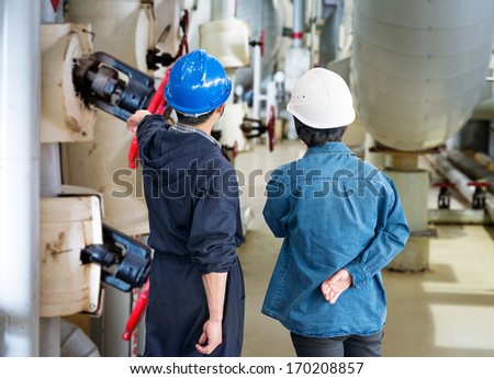 A team of construction workers with helmets at work place in a factory