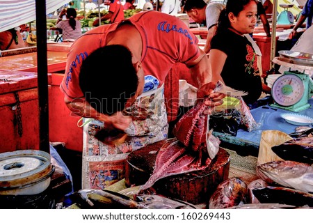 KOTA KINABALU, SABAH, MALAYSIA - FEB 2: Unknown man processing fish for sale on Feb 2, 2011 at a wet  market in Kota Kinabalu, SABAH.