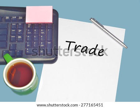 Keyboard with text TRADE on table with tea, calculator and pen
