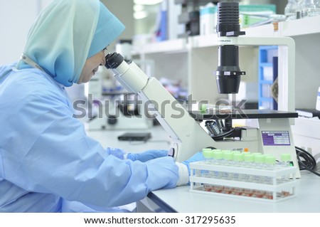 KUALA LUMPUR, MALAYSIA -JUNE 14: Laboratory personnel testing and checking  specimens at Lab Department on JUNE 14, 2012 in Kuala lumpur.