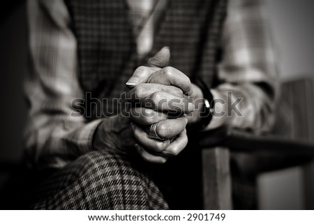 An old widow is praying while mourning her late husband