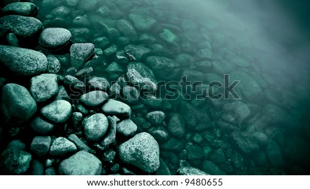 round stones at the river\'s edge