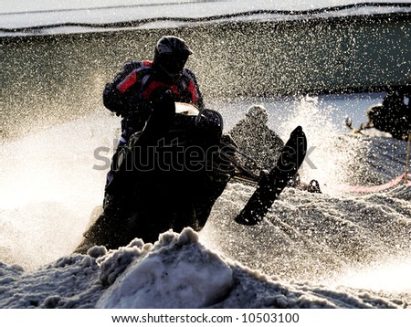 A snow mobile racing in full speed