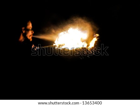 fire artist blowing a ball of fire