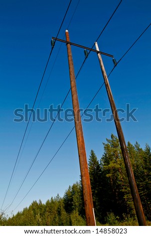 electric power lines on wooden poles in a rural scenery