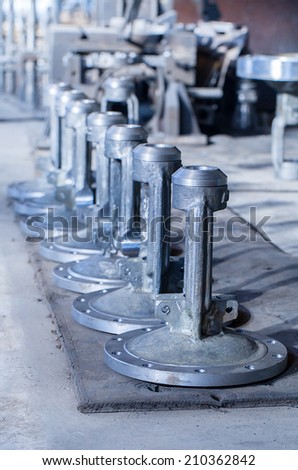 Part of big gate valves after machining in the old factory with selective focus on first bonnet