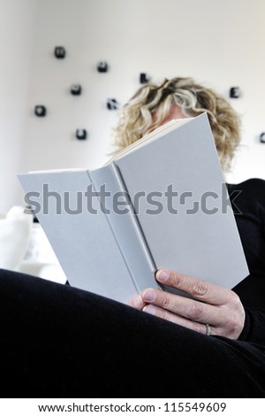 person sitting reading a white cover book