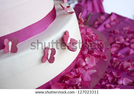 wedding cake decorated with rose petals and butterflies