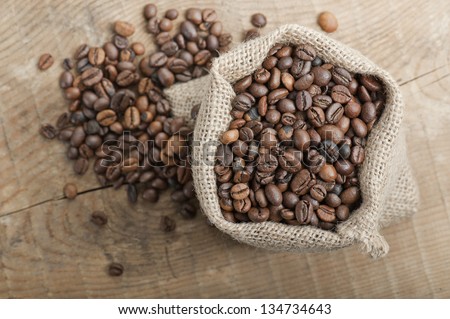 coffee beans in jute bag on wooden table