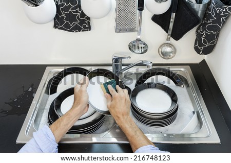 Man in kitchen who cleans the dishes