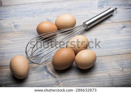 group of eggs with beater on wooden table