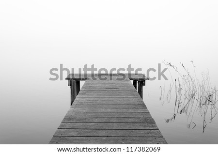 A pier with the view on a foggy lake