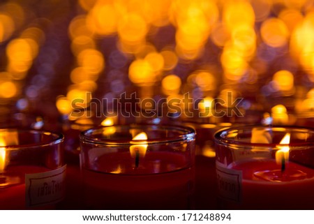 Church candles in red transparent chandeliers
