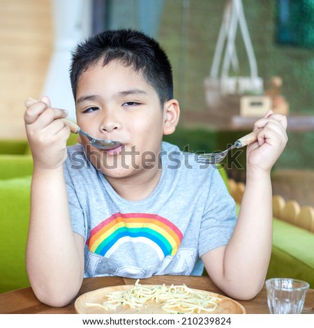 Cute Asian little boy enjoying food