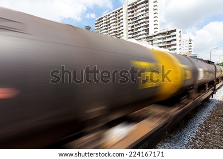 Railroad train of tanker cars transporting crude oil on the tracks with motion blur effect