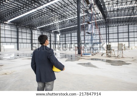worker or engineer holding yellow helmet for workers security in a construction site warehouse