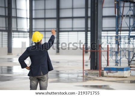 engineer with yellow helmet for workers scontrol a construction site warehouse