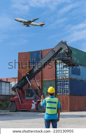 foreman control forklift handling the container box load to big truck selective in import export logistic zone