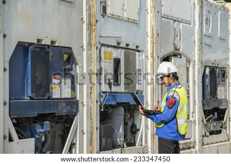 transportation engineer with pc checking reefer container box in logistic zone