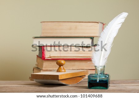 Vintage quill and inkwell,  blotter, old books on wood
