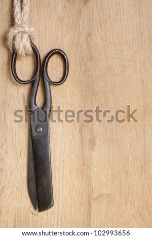 Vintage scissors hanging on wood with rope knot