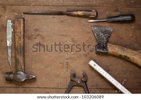 Vintage work tools on grunge wood in frame composition