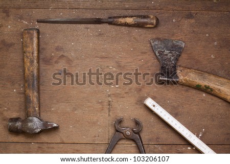 Vintage work tools on grunge wood in frame composition