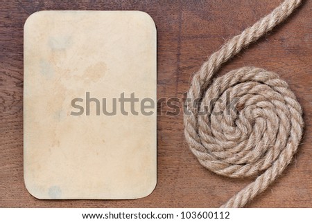 Old paper frame and rope on wooden textured background