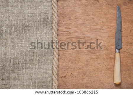 Old knife on oak wood and canvas with rope background
