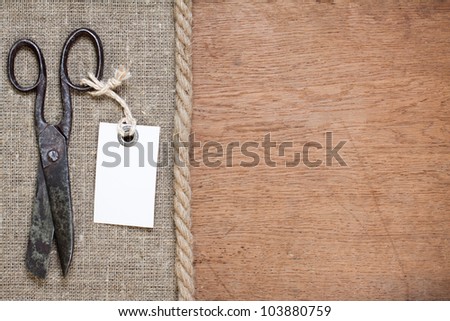 Old scissors on canvas and wood textured background with price tag