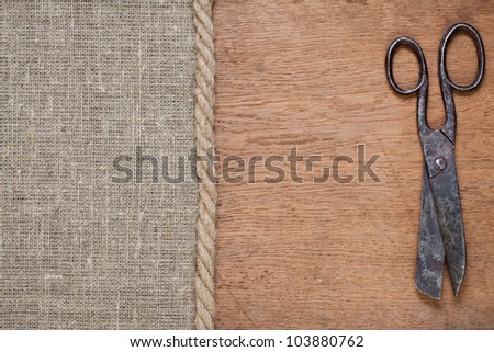 Old scissors on canvas and wood textured background