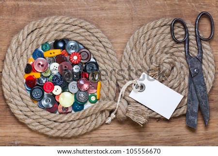 Color buttons in rope frame, old scissors, price tag on wood