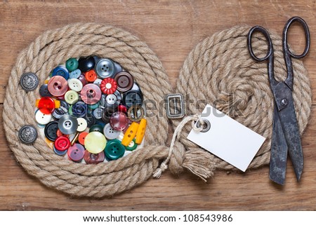 Rope frame with color buttons, old scissors, price tag on wood