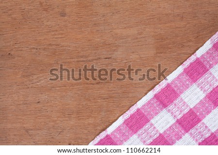 Pink and white kitchen textile texture on wood background