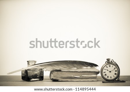 Pocket watch, quill pen and inkwell, book on the table