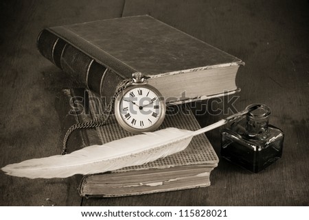 Pocket watch, quill pen and inkwell, book on the table