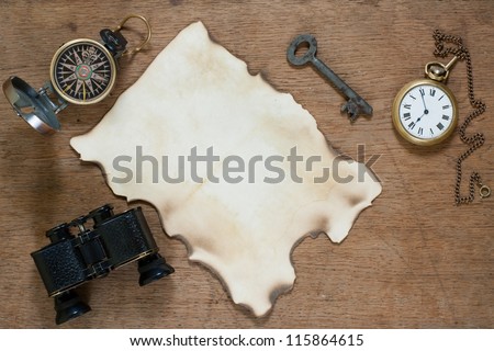 Grunge paper, compass, binoculars and antique pocket watch on wooden background