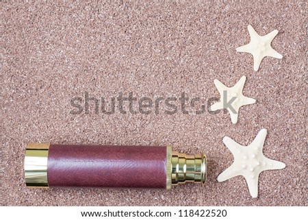 Sand background texture with spyglass and starfish