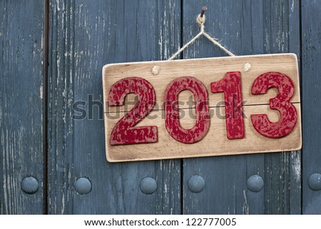 Vintage New Year date sign board on wooden planks background with rope hanging on nail